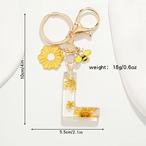 Détail du porte-clés lettre L en résine avec de vraies fleurs séchées jaunes