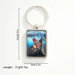 Rectangle western cowboy keychain with a scene of a cowboy riding across a snowy river