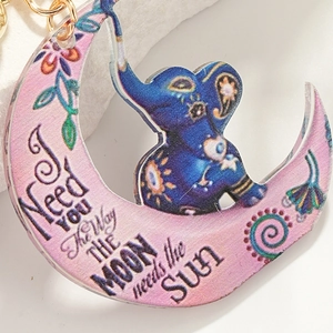 Detail of crescent moon and elephant acrylic keychain with I Need You quote and gold ring