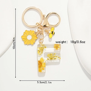 Détail montrant les dimensions du porte-clés lettre F en résine avec fleurs séchées