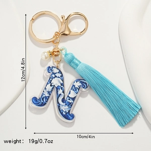 Detailed view of Letter N keychain with blue floral patterns and soft tassel fringe