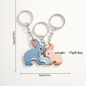 Détail des dimensions de trois porte-clés lapin de dessin animé en bleu et rose pastel