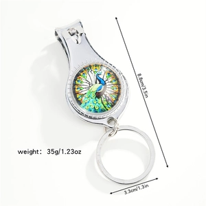 Detail of dragonfly nail clipper keychain with colorful peacock pattern and size specs