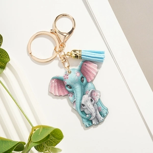 Detailed view of baby elephant keychain with blue tassel and gold metal hardware
