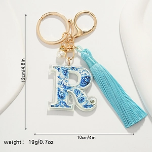 Detail of letter R keychain with blue porcelain pattern, silk tassel and measurements