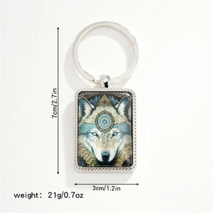 Detail view of a metallic wolf head keychain with blue eyes and bohemian art patterns