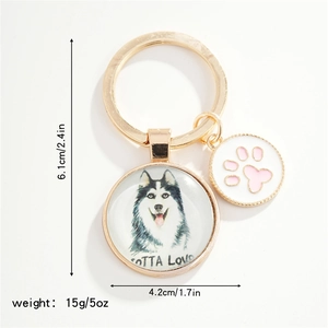 Detail view of golden husky charm keychain with pink paw print and gotta love text
