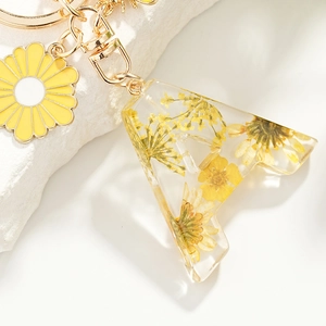 Porte-clés lettre A en résine avec fleurs séchées jaunes et pendentif marguerite