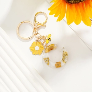 Porte-clés marguerite avec pendentif lettre C doré et breloque abeille en perle