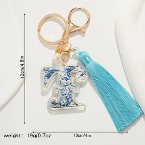 Detail of blue and white porcelain letter F keychain with tassel and size measurements