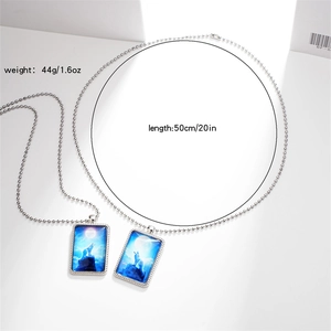 Detail of dual rectangle wolf pendants featuring blue moonlit art and silver bead chains