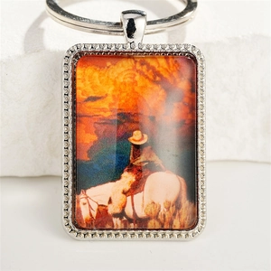 Western cowboy keychain featuring a silver horse riding pendant with sunset scenery