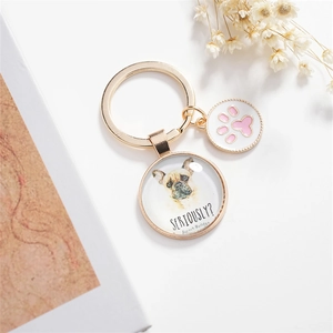 Golden French Bulldog key chain with pink paw charm and flower background detail