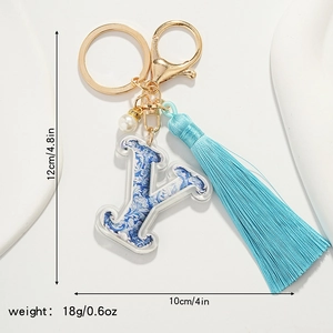 Blue porcelain style letter Y keychain with silk tassel and pearl detail on white background
