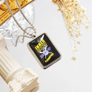 Close-up of rectangular pendant necklace with baseball theme and champion quote