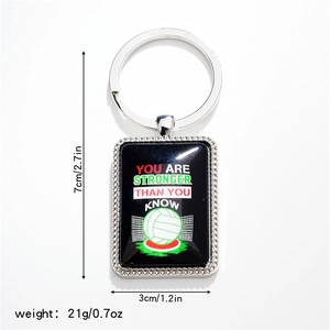 Detail view of volleyball metal keychain showing size markings and inspirational quote