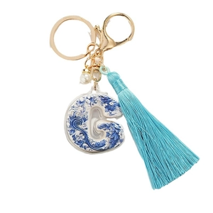 Blue and white porcelain style letter G keychain with tassel and gold hardware