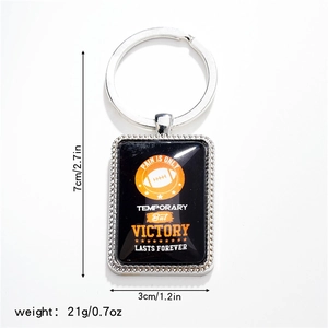Macro shot of rectangular rugby keychain with orange ball pattern and dimensions