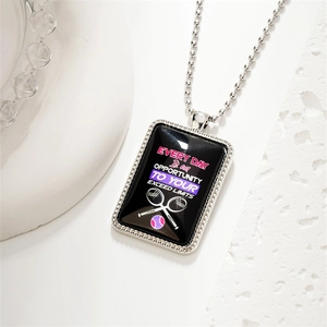 Détail macro du pendentif de tennis rectangulaire avec citation motivante et chaîne à billes