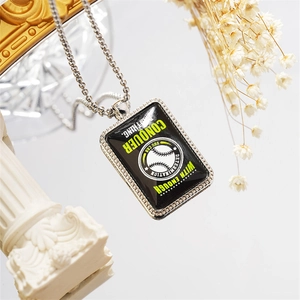 Macro view of inspirational baseball pendant necklace with silver bead chain on reflective base