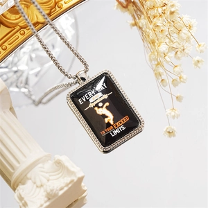 Detailed close-up of volleyball dog tag pendant with motivational quote on a pedestal
