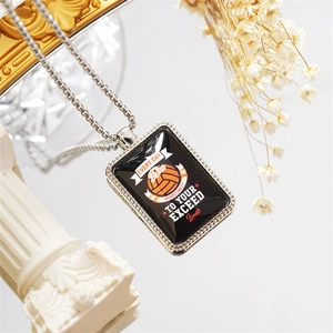 Macro shot of volleyball pendant with inspirational quote on marble surface