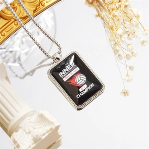 Detail of volleyball necklace featuring INNER STRENGTH engraving and silver bead chain