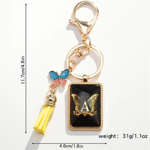 Detail of butterfly keychain with blue glitter pendant, yellow tassel, and letter A charm