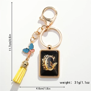 Detail of letter G keychain with blue butterfly, yellow tassel and size dimensions