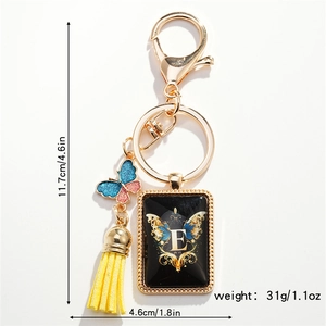 Detail view of letter E butterfly keychain with yellow tassel and dimensions marking
