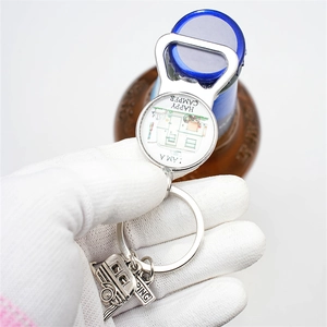 Detail of silver metal happy camper keychain bottle opener with caravan charms