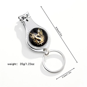 Close-up of a silver 3-in-1 multi-functional nail clipper keychain with golden letter S