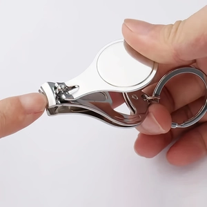 Close-up of portable stainless steel folding nail clipper with key ring being used