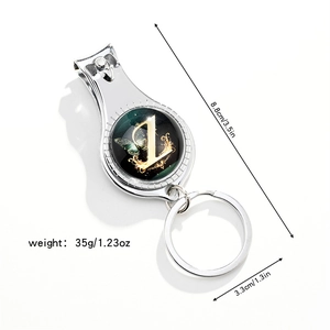 Close-up of multifunctional keychain nail clipper with butterfly and gold letter L