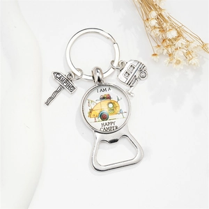 Detail of happy camper keychain bottle opener with silver trailer and camping sign charms