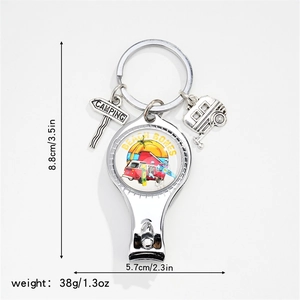 Detail of camping nail clipper keychain with caravan and road sign charms in silver metal
