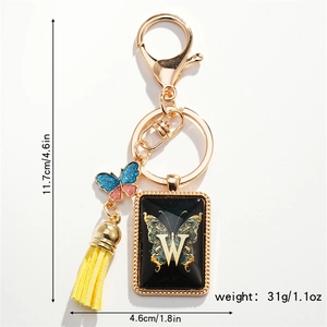 Detail of letter W keychain with blue butterfly charm and yellow fringe tassel pendant