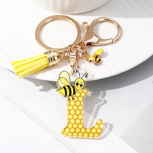 Macro view of acrylic letter L keychain with honeycomb pattern and yellow leather tassel