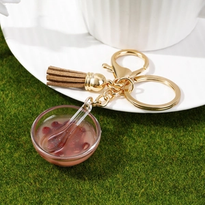 Macro detail of miniature red bean soup bowl keychain with resin texture and brown tassel