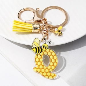 Detail of bee keychain with yellow leather tassel and acrylic letter Q with honeycomb