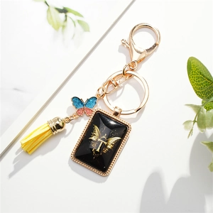 Golden keychain with letter T pendant, colorful glitter butterfly and yellow tassel charm