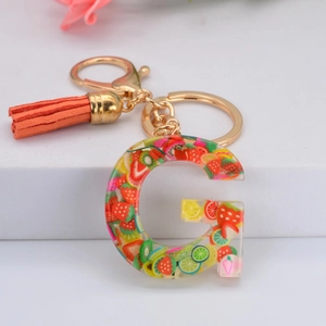 Porte-clés lettre G en résine avec tranches de fruits, métal doré et pompon orange