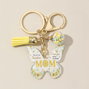 Macro view of butterfly acrylic keychain with Mom text, yellow tassel, and glass ball