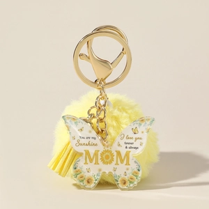 Detail of MOM acrylic butterfly keychain with yellow faux fur pompom and tassel charm