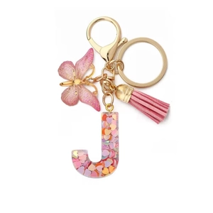 Detail of pink resin letter J keychain with glitter hearts, butterfly charm and tassel