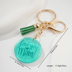 Détail du porte-clés en résine vert menthe avec motif Love You Mom et pompon en cuir
