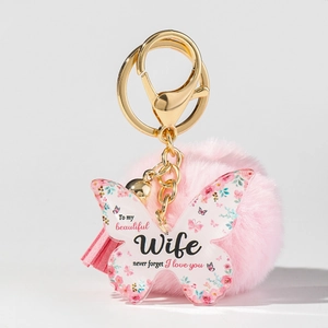 Detailansicht Schmetterling-Schlüsselanhänger mit rosa Bommel und Geschenktext für Ehefrau
