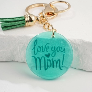 Détail du porte-clés en résine sarcelle avec pompon et texte love you Mom pour Fête des Mères