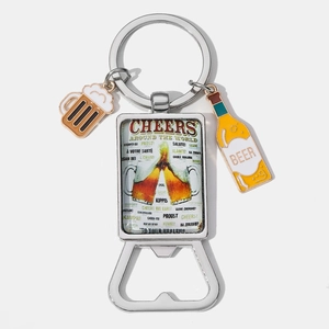 Macro view of portable metal bottle opener keychain with cheers engraving and beer charms
