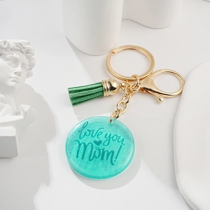 Détail d'un porte-clés en résine sarcelle avec gravure Love you Mom et gland vert
